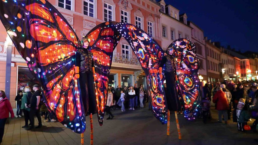 An evening parade featuring two LED Butterfly Performers on Stilts