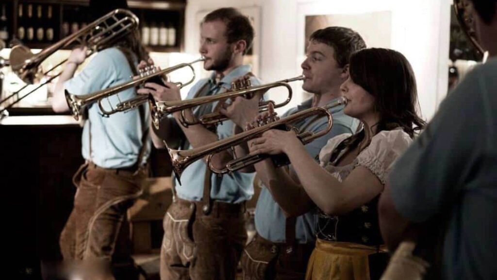 A bavarian band in German costume playing instruments for a german international themed event.