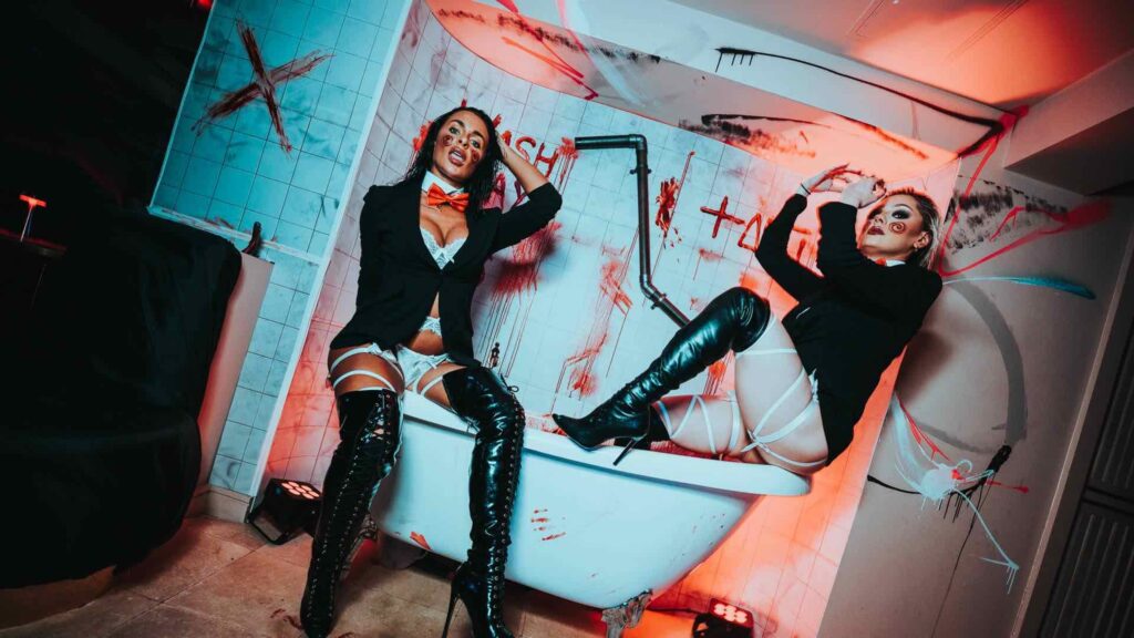 SAW themed Halloween theming by halloween theming company featuring bathtub scene from SAW movie with posing ladies.