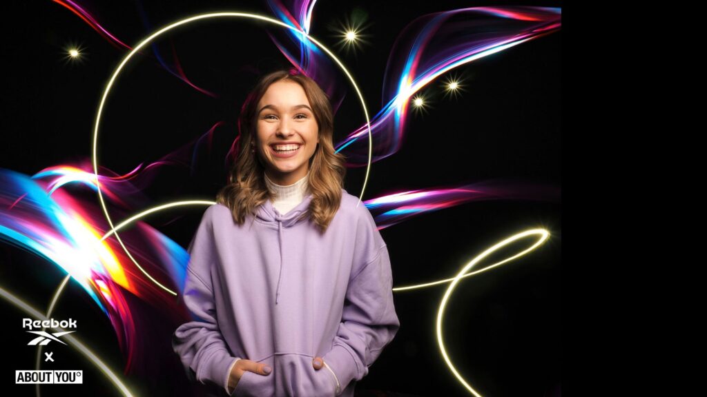 Lighting painting portrait of a smiling girl with beautiful light trails created by an artist for a brand activation event.