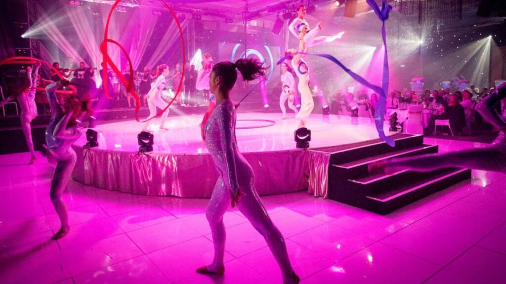 Olympic themed acrobatic troupe performer on stage at a gala dinner performing routine.