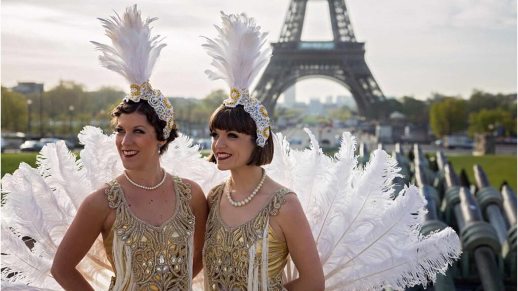 Showgirl dancers standing in front of the Eiffel Tower.