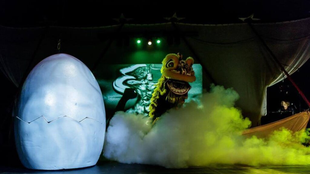 Metamorphosis Contortion Act on stage, smoke fills the floor with a large white egg and a Chinese dragon captivating guests