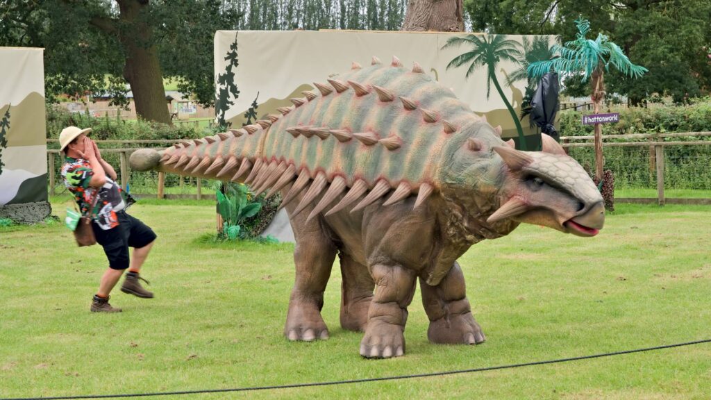 Angie the Ankylosaurus swinging her tail at a ranger.