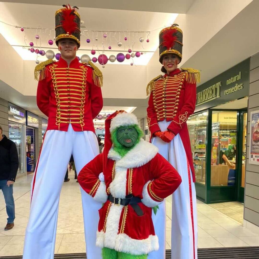 Nutcracker Stilt Walkers posing with the Grinch at a shopping centre
