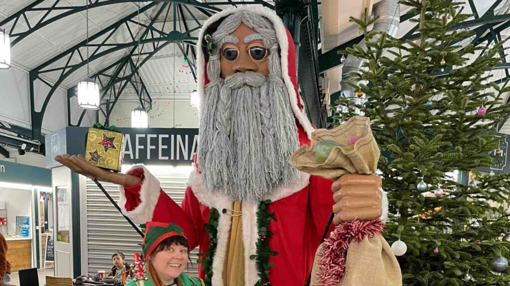 Giant puppet santa and elf performer at shopping centre activation.