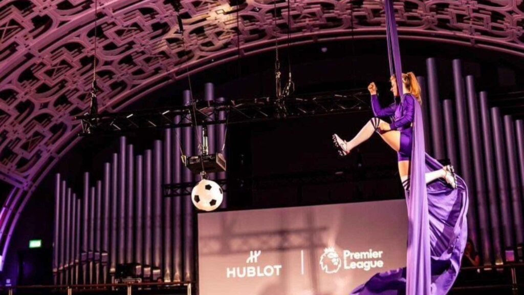 Aerialist in football theme above the stage using height of venue to perform.