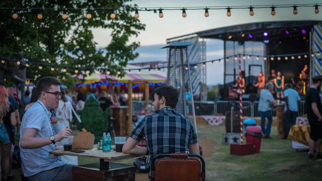 Guests relaxing at an outdoor festival event during the summer