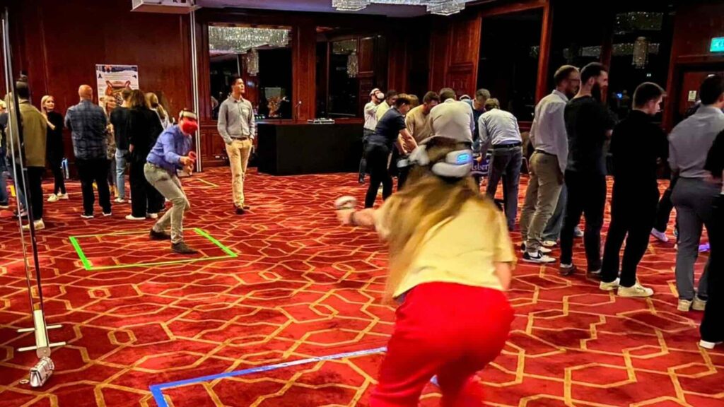 Employees engaging with corporate Metaverse gaming experience after conference event.