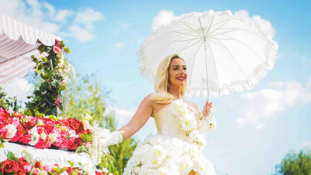 Entertainer dressed in a floral outfit and holding an umbrella