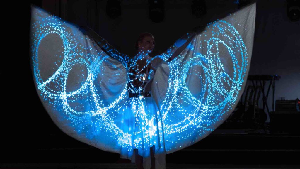 Entertainer wearing wings that are lit up with an LED screen.