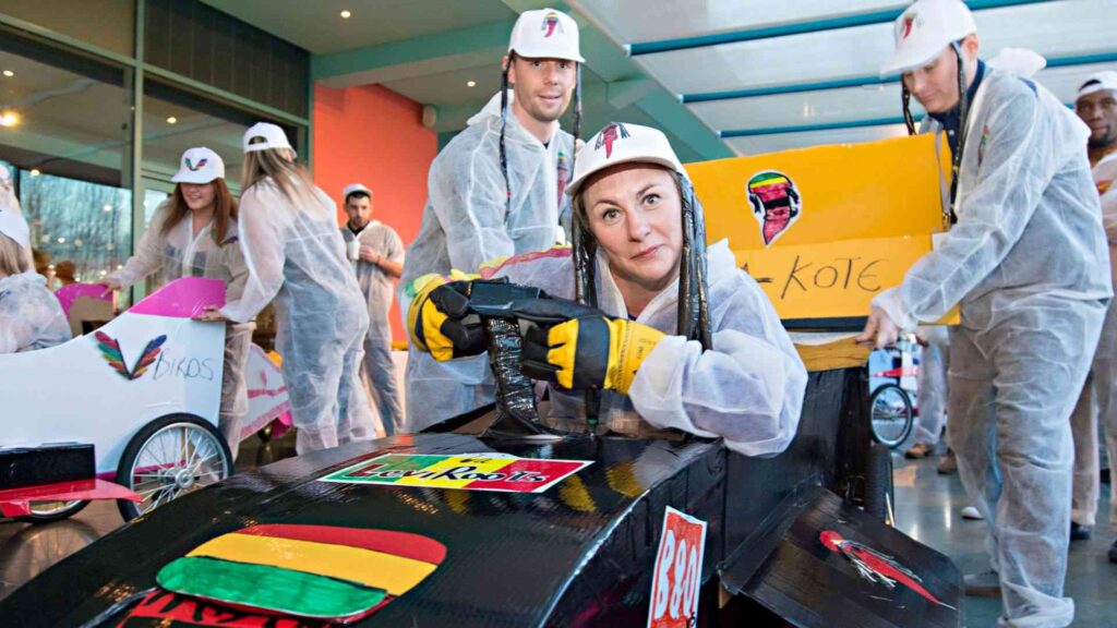 Group of employees having fun with an F1 team building activity as Interactive conference ideas