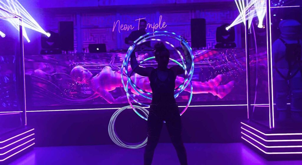 LED hula hooper performing in front of cyborg space themed event props.
