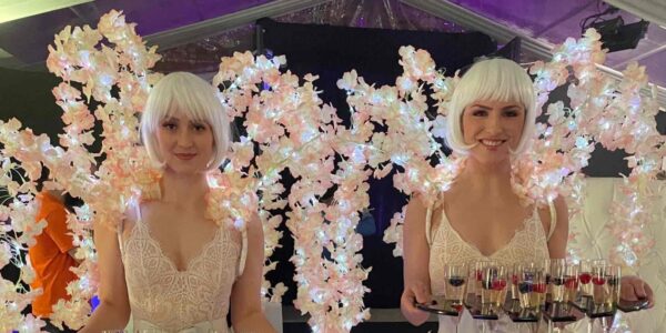 All white party champagne meet and greet ladies with stunning floral background.
