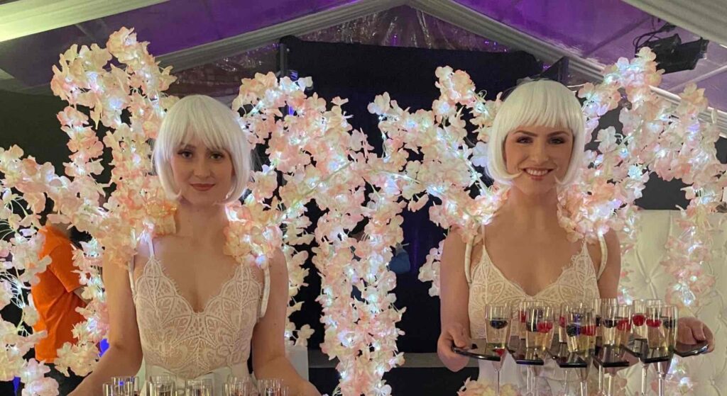 All white party champagne meet and greet ladies with stunning floral background.