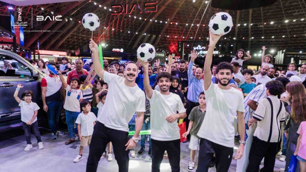 Three Freestyle Football Entertainers holding footballs in the air