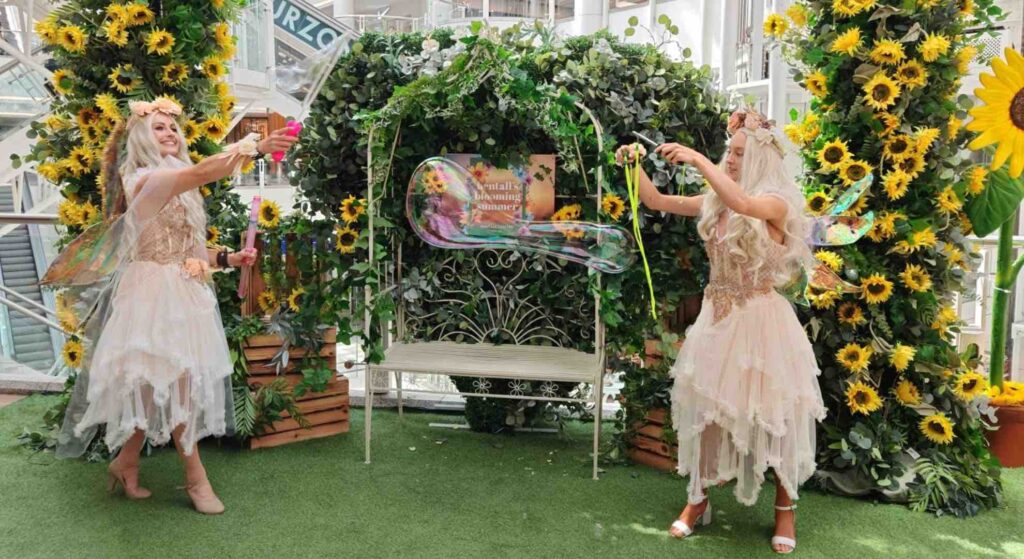 Spring themed fairy performers handing out gifts at a retail shopping event.
