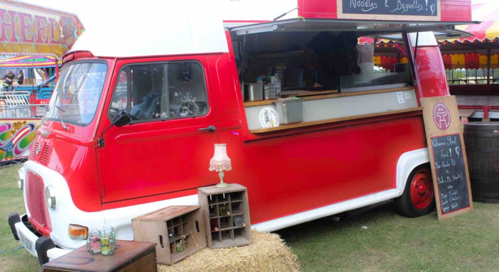 Red campervan at a mini festival.