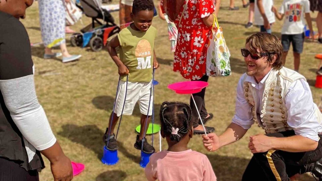 A Circus Skills Workshop guide interacting with young children