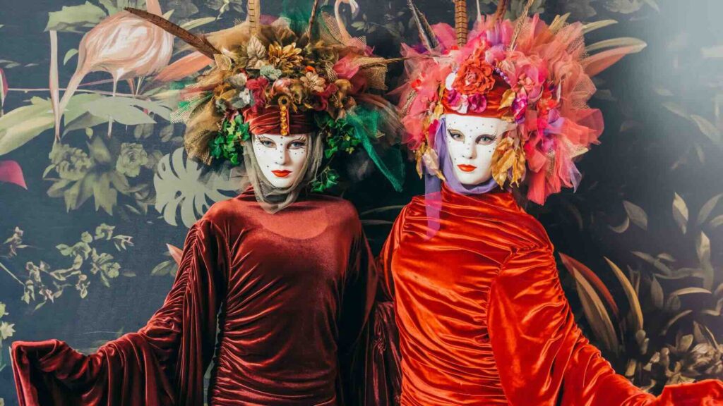 Two floral walkabout characters posing for a photo in front of a floral wall