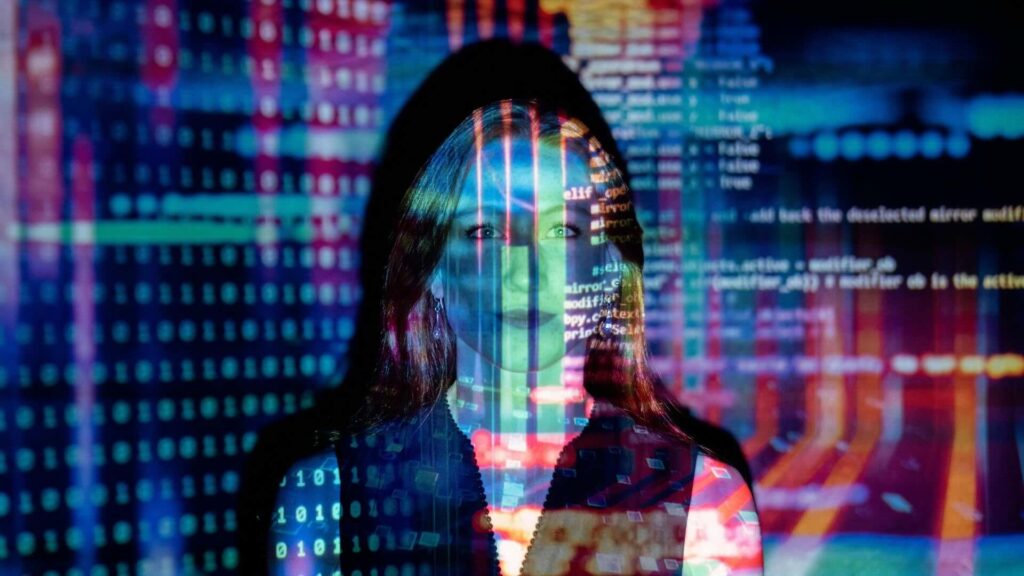 Woman standing in front of coding projection.