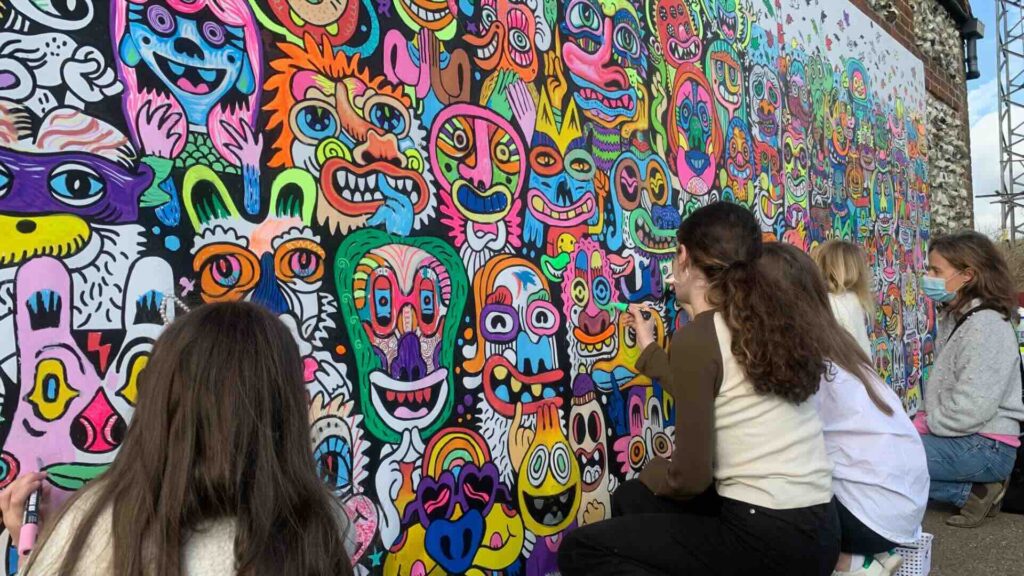 Attendees drawing on an interactive doodle wall at an event