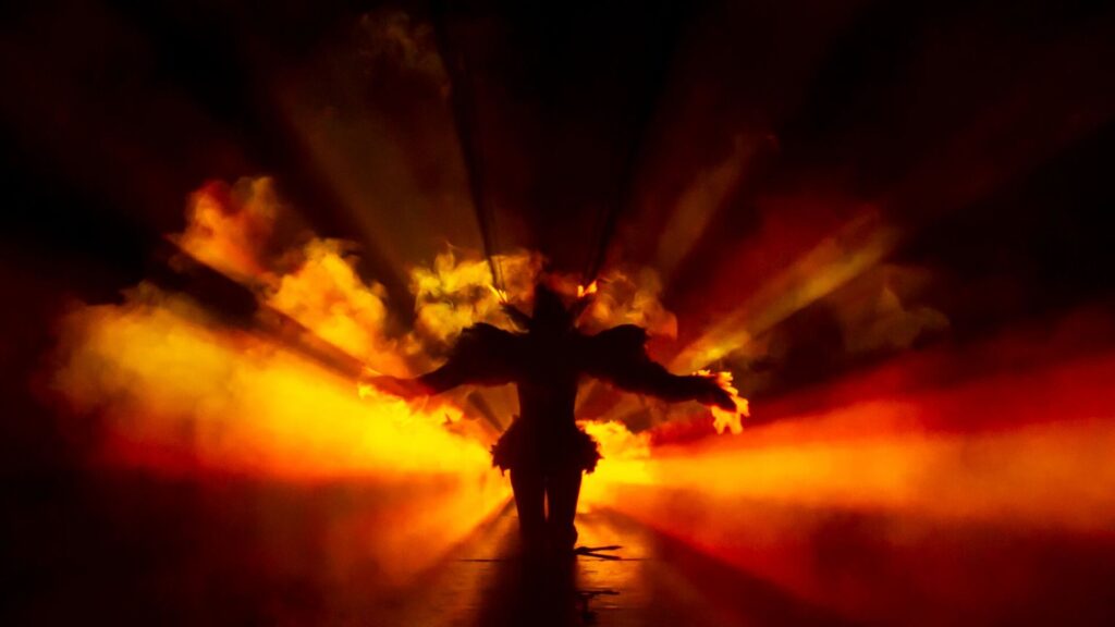 A person illuminated by warm orange lighting and fog with interactive digital walls
