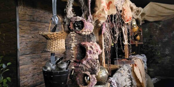 Ancient Egypt event theme marketplace installation with hanging props, textiles and tools for an authentic experience.