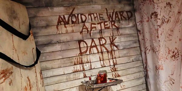 A close-up of the blood-smeared message “NO RETURN” sends a haunting warning, setting the tone for a terrifying Asylum-themed experience.