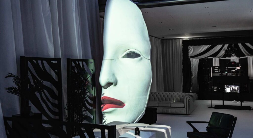 Black and white event theming featuring a glowing mask 3d projection prop curated for the Sidemen event.