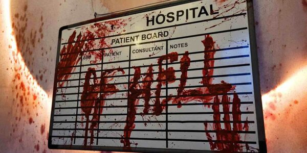 A close-up of the "HOSPITAL OF HELL" sign, drenched in blood, sets a sinister tone, immersing guests in the terrifying Asylum-themed event.