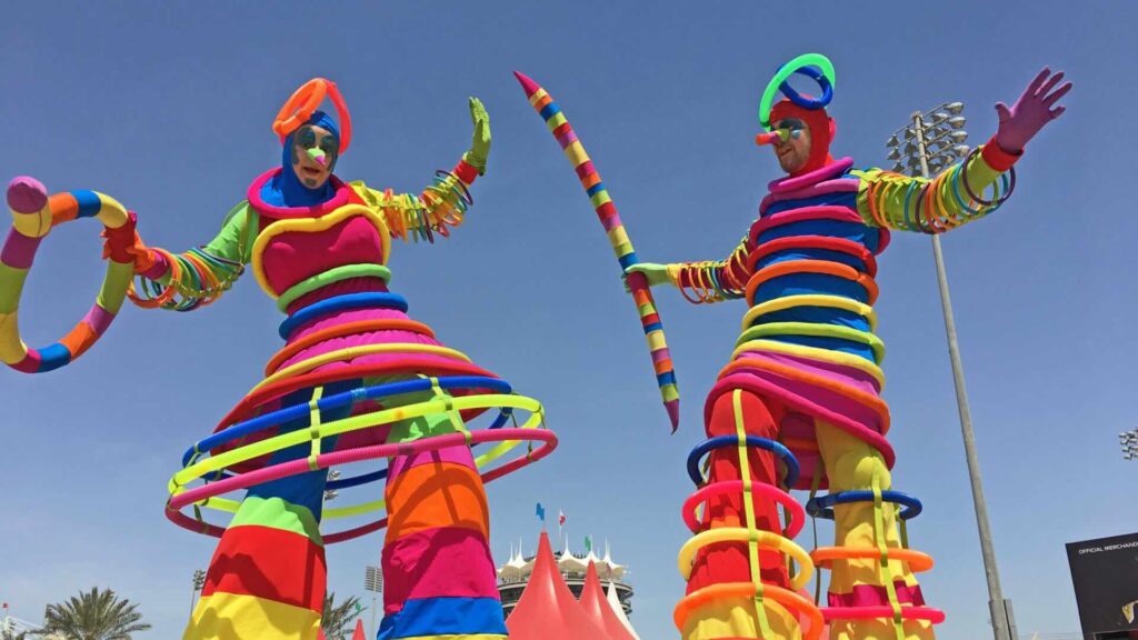 A duo of colourful stilt walkers at an outdoor event