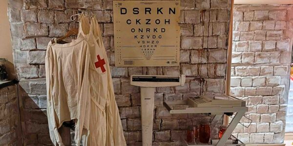 A close-up of the old weighing scale and bloodstained aprons captures the unsettling medical atmosphere, heightening the horror of the Asylum-themed event.