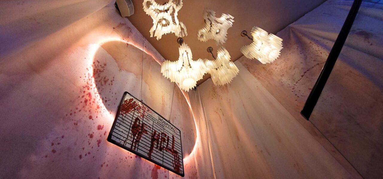Hanging hospital patient sign covered in fake blood with the message HOSPITAL OF HELL greets nightclubbers at TABU nightclub Asylum themed event.