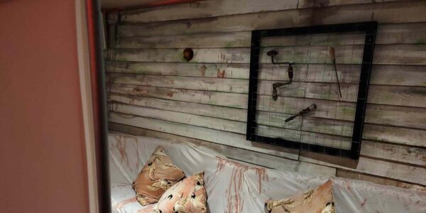 Creepy turn of the century hospital tools hang in a cage as part of event decor for Asylum horror event theming.