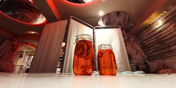 With eerie lighting highlighting two mason jars and an ominous hospital partition screen, this setup creates a tense, otherworldly vibe for the haunted event.