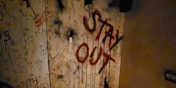STAY OUT sign scrawled on the wall of this Asylum themed event.