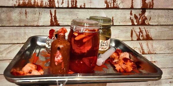 Grotesque Mason jar props with body parts and syringes, part of a haunted Hospital event set design.