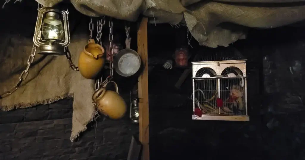 A custom built Egyptian market for a Halloween event, featuring an eclectic mix of props, including hanging pots and cages adorned with eerie, gory decorations.