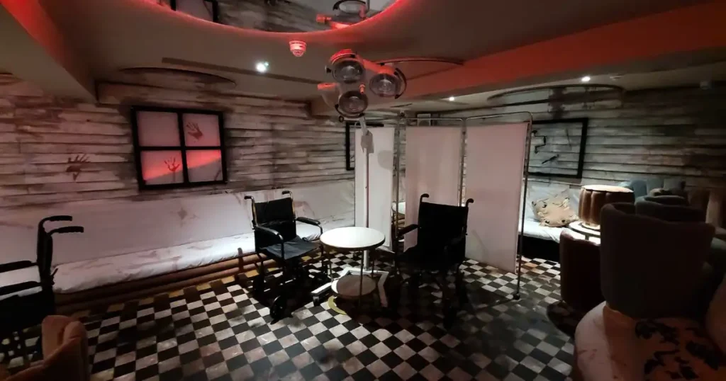 Two wheelchairs sat in front of a medical folding screen with eery operation lights - all part of a Halloween venue transformation for TABU nightclub. 