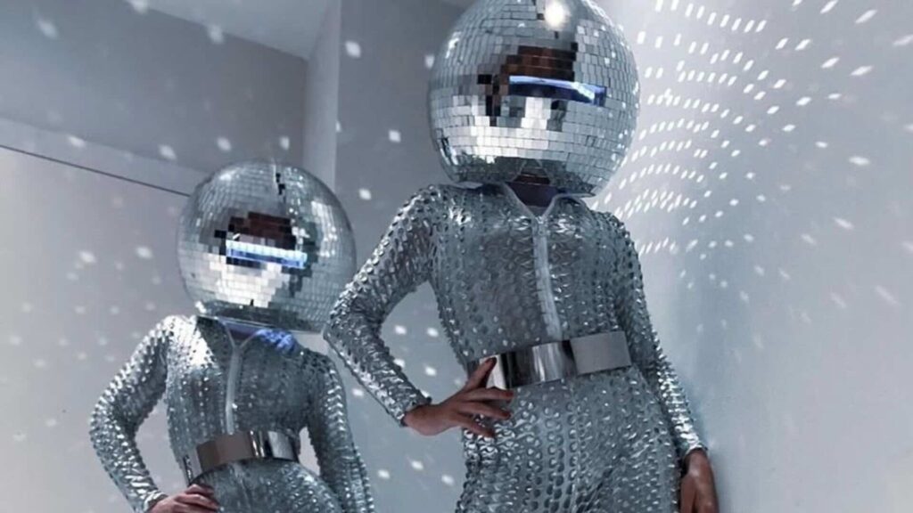 A disco-ball head mirror walkabout act posing for a photo.