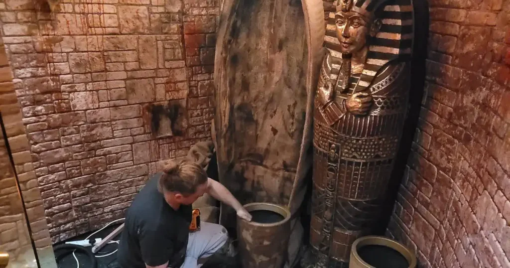 Member of production team painting Egyptian themed set design at REIGN showclub. 