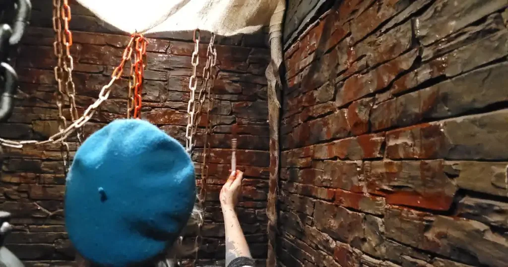 Our event set dresser splattering red paint onto wall at venue to transform it for a prison cell for a Halloween event. 