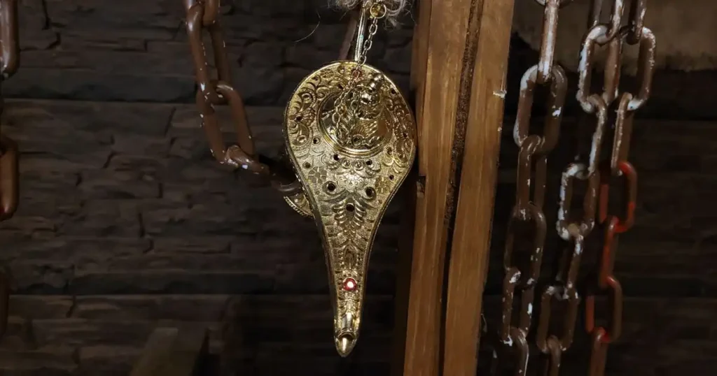 Hanging silver lamp prop used to decorate a Halloween set design.