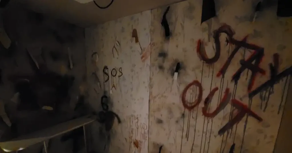 "Stay out" warning sign scrawled on the walls of a Halloween venue styling in London TABU as part of an Asylum theme. 