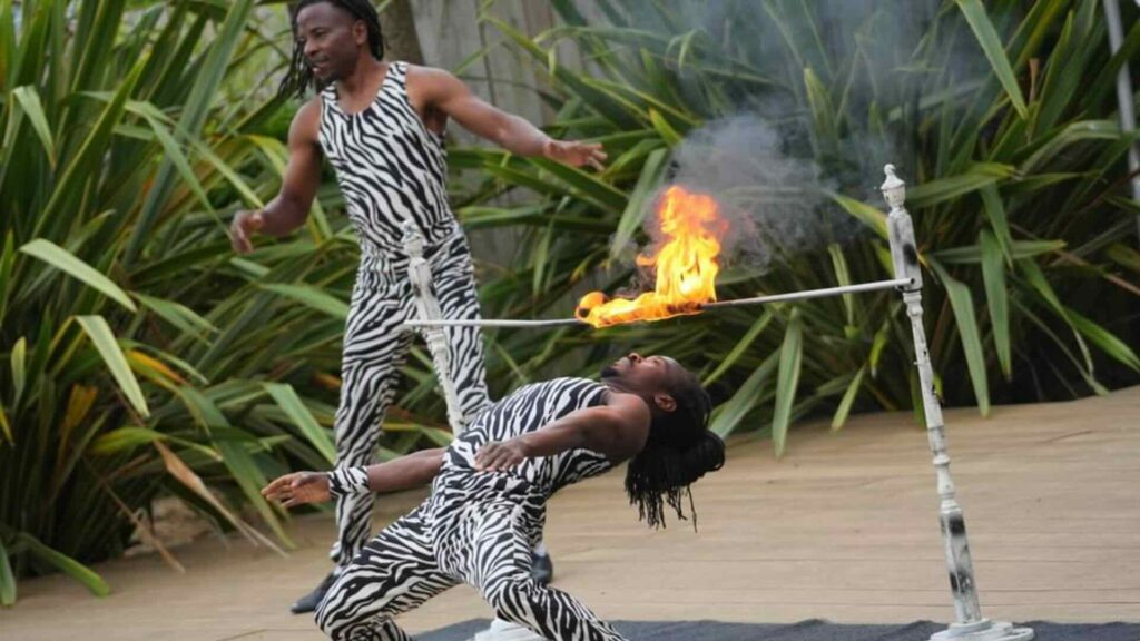An outdoor African themed acrobatic show with fire.