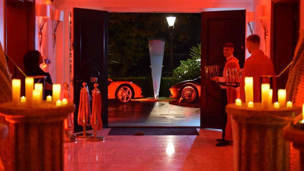 A cult awakening Halloween mansion party entrance with candles and caterers