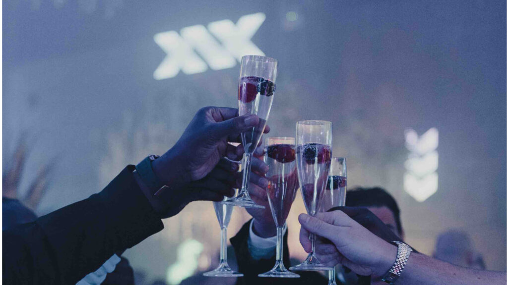 People clinking drinks at a gala event.