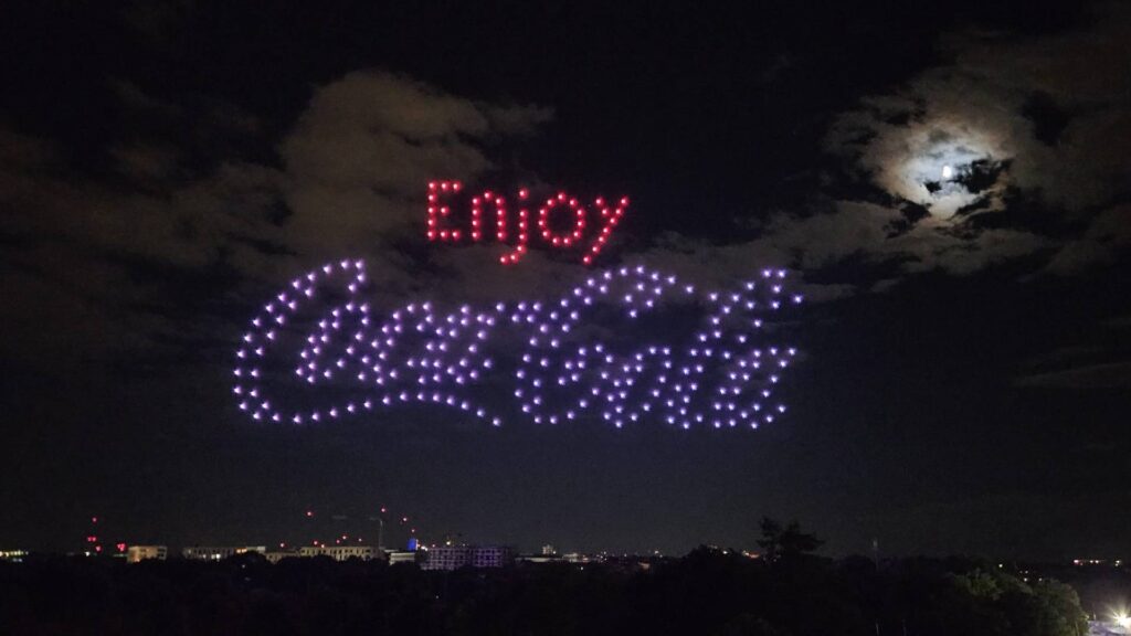A drone show performance in the sky, promoting coca cola.