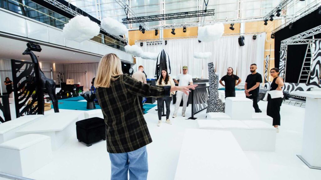 Event manager communicating and managing team setting up an event space.